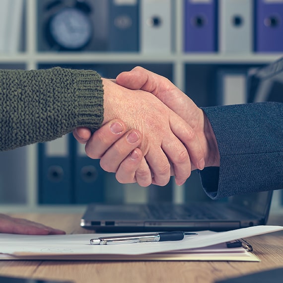 Man and woman shaking hands over business
